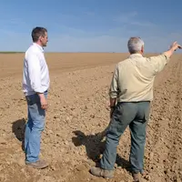 Cédant et repreneur en discussion dans une parcelle.