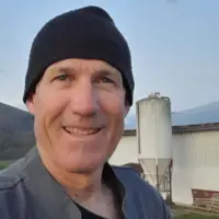 Charles Iralour, agriculteur à Ainhice-Mongelos (64), devant son bâtiment d'élevage couvert de panneaux photovoltaïques.