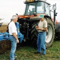 Agriculteurs discutant devant du  matériel.