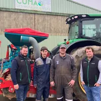 Groupe d'agriculteurs devant un tracteur et un semoir.