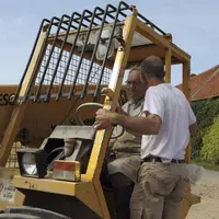 Agriculteur à la retraite avec son fils conduisant un valet de ferme.
