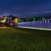 Pulvérisateur sur une parcelle dans la nuit.