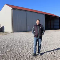 <em class="placeholder">Julien Bricquet devant son bâtiment d'exploitation initialement construit sur un terrain appartenant à son père</em>