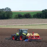 Tracteur semant du colza dans une parcelle.