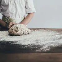 Un boulanger fait son pain avec de la farine.