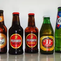 Cinq bouteilles de bières françaises de différentes marques.