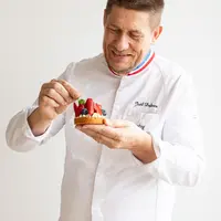 Le boulanger MOF, Joël Defives, avec une pâtisserie à base de blé dur Panzani solutions dans la main.