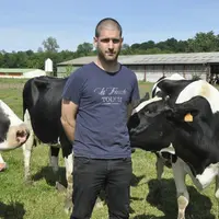 Laurent Bernadieu, éleveur. Au fond, la stabulation des vaches et le poulailler en prolongement. © B. Griffoul