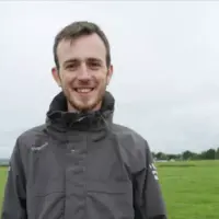 Alann Jezequel, en thèse à Moorepark (Teagasc) en Irlande, devant une pâture.