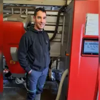 Anthony Bretaudeau, éleveur devant son robot de traite