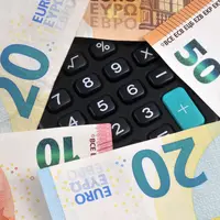 Calculator keyboard surrounded by euro banknotes close-up | Clavier de calculatrice entouré de billets de banque en euros en gros plan
