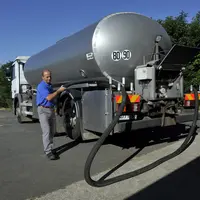 Salarié de la laiterie chez l' éleveur près du camion, dans la cour de ferme.
