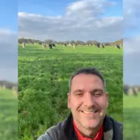 Selfie de Yohann Allain dans son champ avec ses vaches laitières.