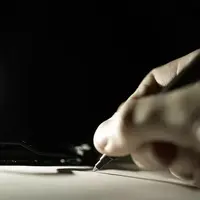 main qui signe un contrat sous fond noir