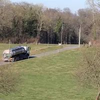 Camion Lactalis dans le bocage ornais. Collecte du lait. pâtures en région d'élevage laitier. route, herbe et arbres. ind