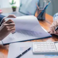 Businesswoman reviewed mortgage document and contract with their client, ensuring loan and credit details were clear, while di