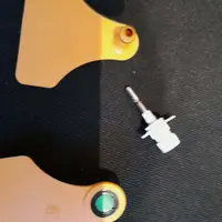 Boucle auriculaire pour prélèvement de cartilage avec le trocard métallique et la cupule récupératrice.