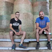 Hugo Barraillé et Florian Gibaud, deux éleveurs assis devant des bottes de paille