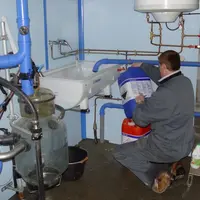 quelqu'un regardant bidon produits nettoyage salle de traite