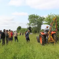 groupe d'éleveurs assistant à une démonstration d'entretien de la végétation autour des clôtures.