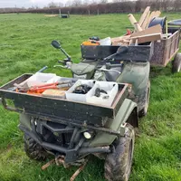 quad dans une prairie avec du matériel pour entretenir et déplacer les clôtures et les fils.