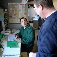 Eleveur donnant les instructions à son salarié. Agriculteur employeur. Transmission des consignes. Discussion. Explication des