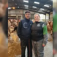 Nicolas et Christelle Braux dans la stabulation devant des vaches simmental