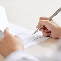 Mains d'une personne signant un document