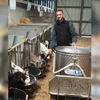 éleveur salarié en train de distribuer du lait aux veaux