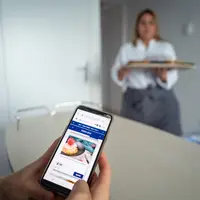 Un patient navigue avec son téléphone portable sur le site de la polyclinique de Jean Vilar pour réserver son repas. © Jeremy Lempin