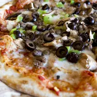 image d'une pizzas aux olives, poivrons et fromages.