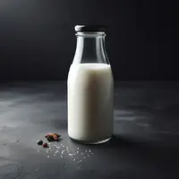 Une bouteille en verre de lait cru, sur fond noir. Style photoshoot