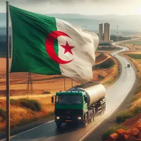 au premier plan un drapeau algérien qui flotte au vent, derrière un camion citerne qui roule sur route rurale