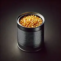 une boite de conserve métallique, sans étiquette, qui contient des grains de maïs, sur fond noir