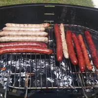 saucisses de chipolatas en cuisson sur barbecue