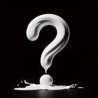 un point d'interrogation fait de lait renversé sur fond noir