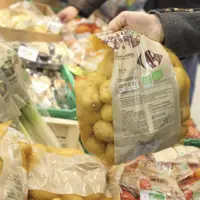 main attrapant un sac de pomme de terre en magasin