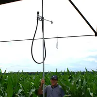 Une canne permet d'accrocher et décrocher l'asperseur de son support depuis le sol.