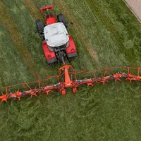 Faneuse Kuhn GF 13003 à 12 toupies en mode bordure avec tracteur Massey Ferguson
