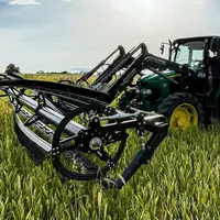 Écimeuse Zürn sur le chargeur frontal d'un tracteur, dans un champ de céréales.