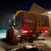 Épandeur d'engrais Bogballe attelé à un tracteur Claas