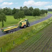 Coupe directe Krone Xdisc 710 en position transport accrochée derrière une ensileuse Krone