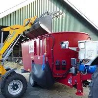 Valet de ferme chargeant une mélangeuse BvL équipée d'un entraînement électrique en plus de l'animation par la prise