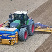Trémie frontale Alpego Airboost sur tracteur Fendt avec herse rotative Alpego de 8 m et barre de semis