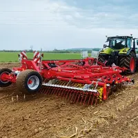 cultivateur Güttler Feldmeister LK 60 en action derrière un tracteur Claas.