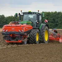 Tracteur John Deere au semis avec la trémie frontale TF 2300 C.