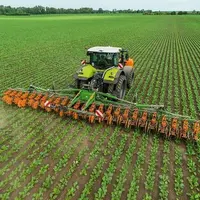 Bineuse Amazone Venterra VR 4 attelé à un tracteur Claas et combiné à une cuve frontale FT-P.
