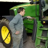 Agriculteur qui fait le plein de son réservoir de tracteur avec du Gazole non routier (GNR).