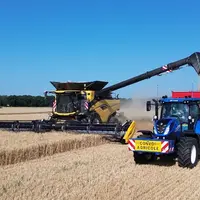 Moissonneuse-batteuse New Holland CR11 à la vidange, avec benne Gyrax et tracteur New Holland