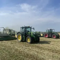 Andaineur à tapis Krone Swativo T 1040 Pro derrière un tracteur John Deere